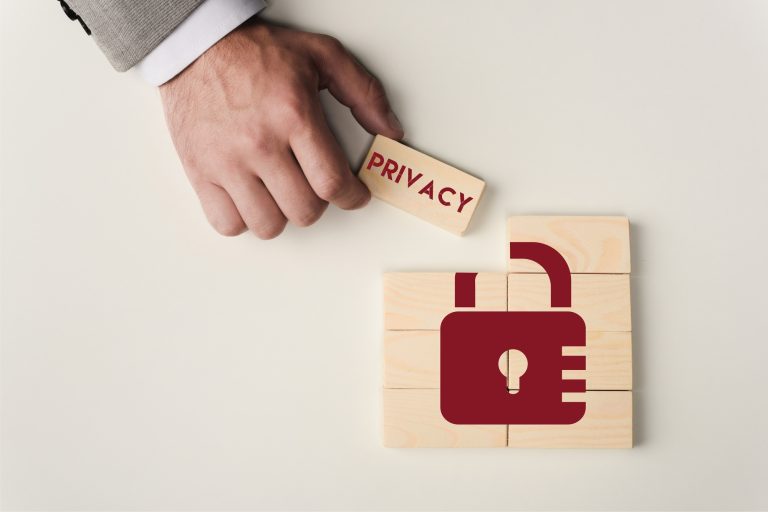 partial view of man holding brick with 'privacy' lettering over wooden blocks with lock icon